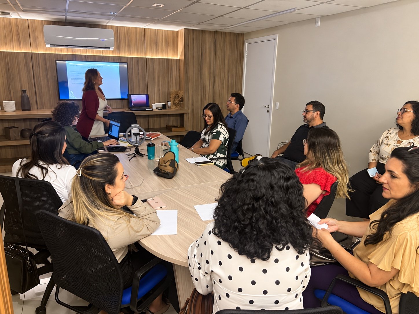 Encontro de capacitação do Expandir, com apresentação e profissionais reunidos à mesa